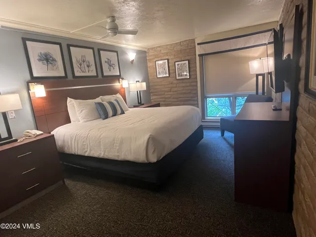 a bedroom with a bed wooden floor and window