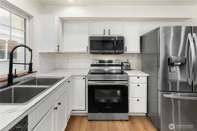 a kitchen with stainless steel appliances granite countertop a refrigerator stove and sink
