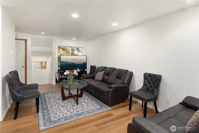 a living room with furniture and a wooden floor