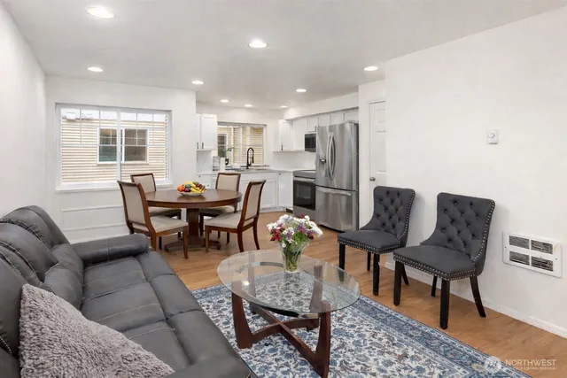 a living room with furniture and a dining table with wooden floor