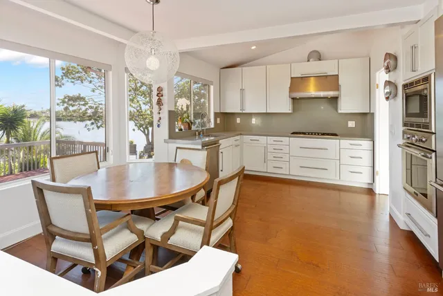a dining room with furniture a chandelier and wooden floor