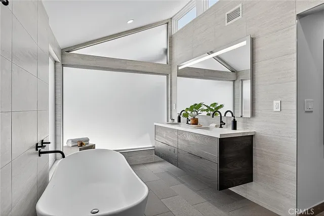 a view of an empty room with a window and a kitchen