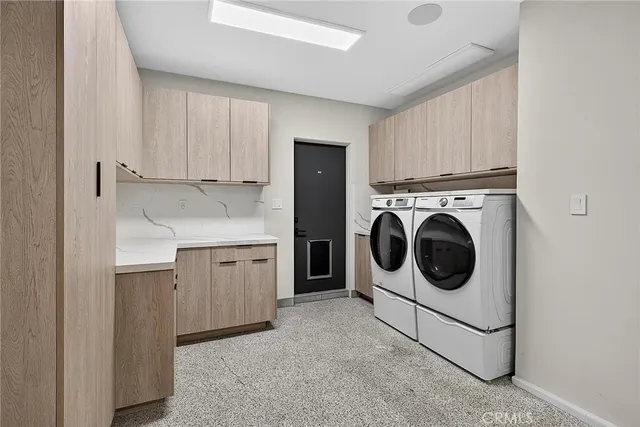 a view of a large building in front of a yard with plants and large trees