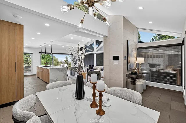 a kitchen with stainless steel appliances kitchen island granite countertop a stove a sink a refrigerator white cabinets and wooden floor