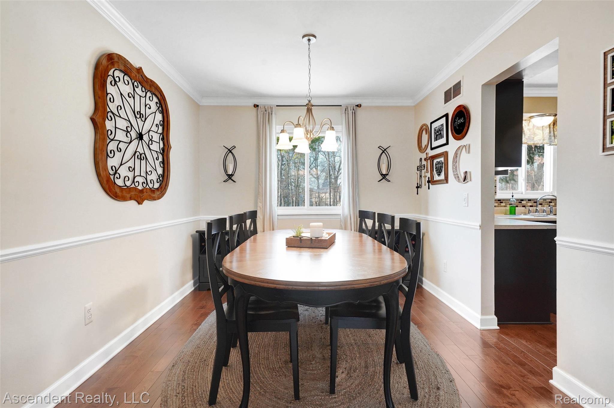 Dining room with newer crown moldings, chair railing and hardwood flooring.
