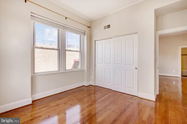 a view of an empty room with wooden floor