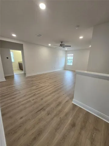 a view of empty room with wooden floor