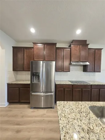 a large kitchen with kitchen island a counter space a sink and a stove