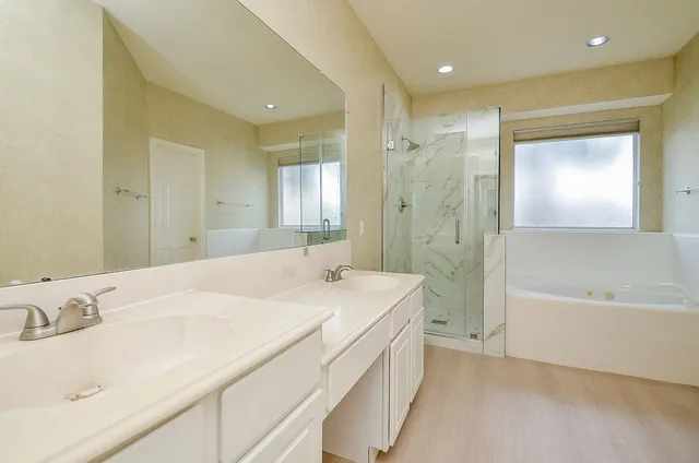 a spacious bathroom with a bathtub sink and mirror