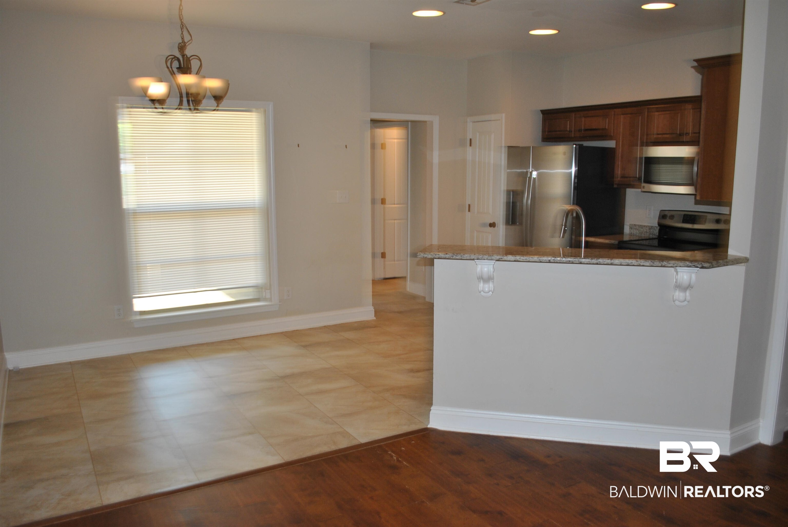 2161 Spring Grove West Mobile, AL 36695 - Photo 9 of 31 Kitchen featuring stainless steel appliances, a peninsula, dark stone countertops, a breakfast bar area, and hanging light fixtures