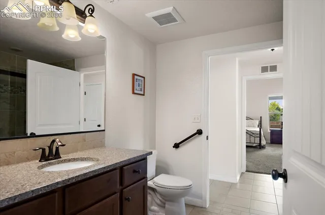a bathroom with a granite countertop sink a toilet and a mirror