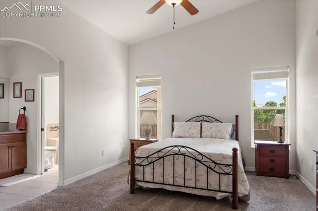 a bedroom with a large bed and a chandelier fan