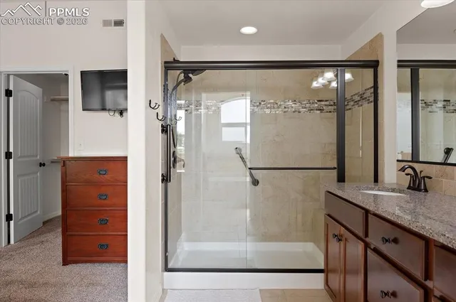 a bathroom with a granite countertop shower sink and mirror