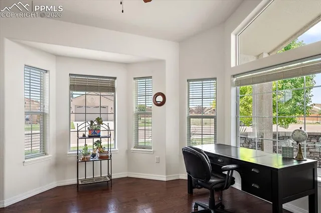a dining room with wooden floor and windows
