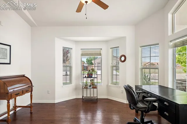 a view of a workspace with furniture and a window