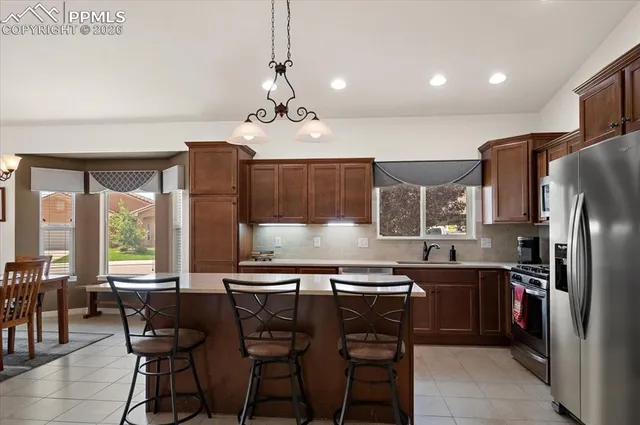 a kitchen with stainless steel appliances granite countertop a sink a stove and a refrigerator