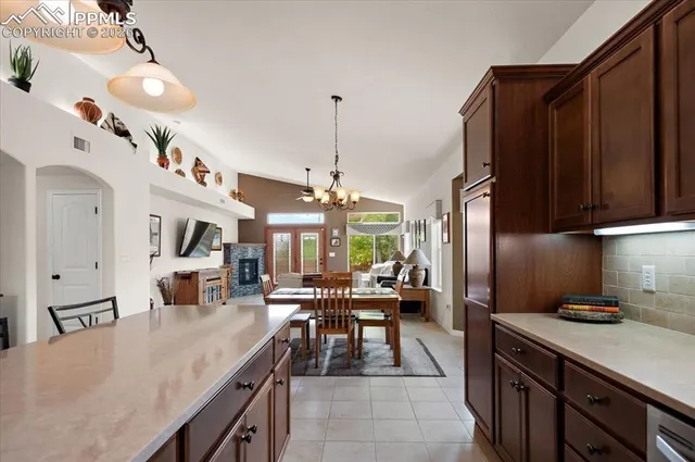 a kitchen with stainless steel appliances granite countertop a stove a sink dishwasher and a dining table with the kitchen view