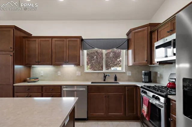 a kitchen with stainless steel appliances a sink stove and microwave