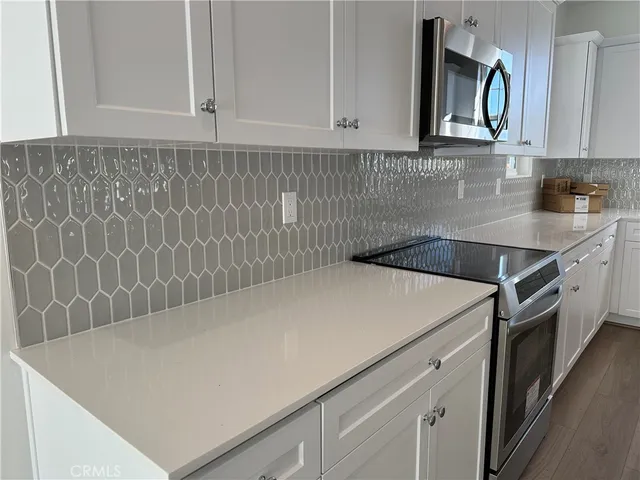 a view of kitchen cabinets and white appliances