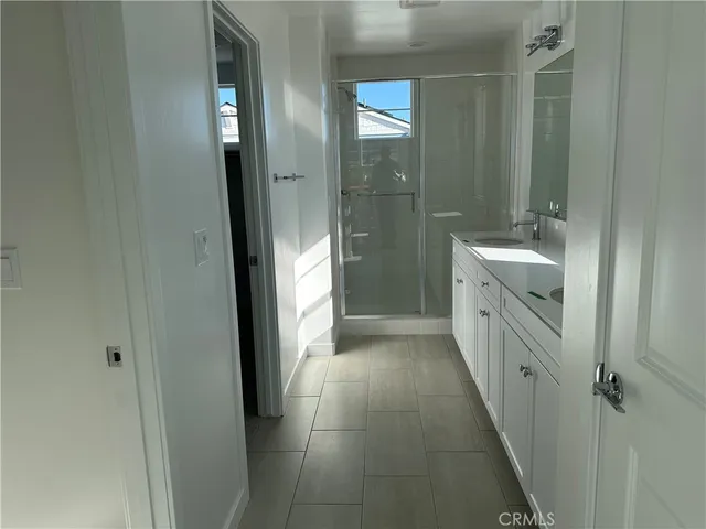 a bathroom with a double vanity sink a mirror and a shower
