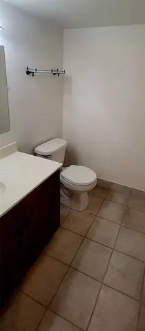 a bathroom with a granite countertop sink and a toilet