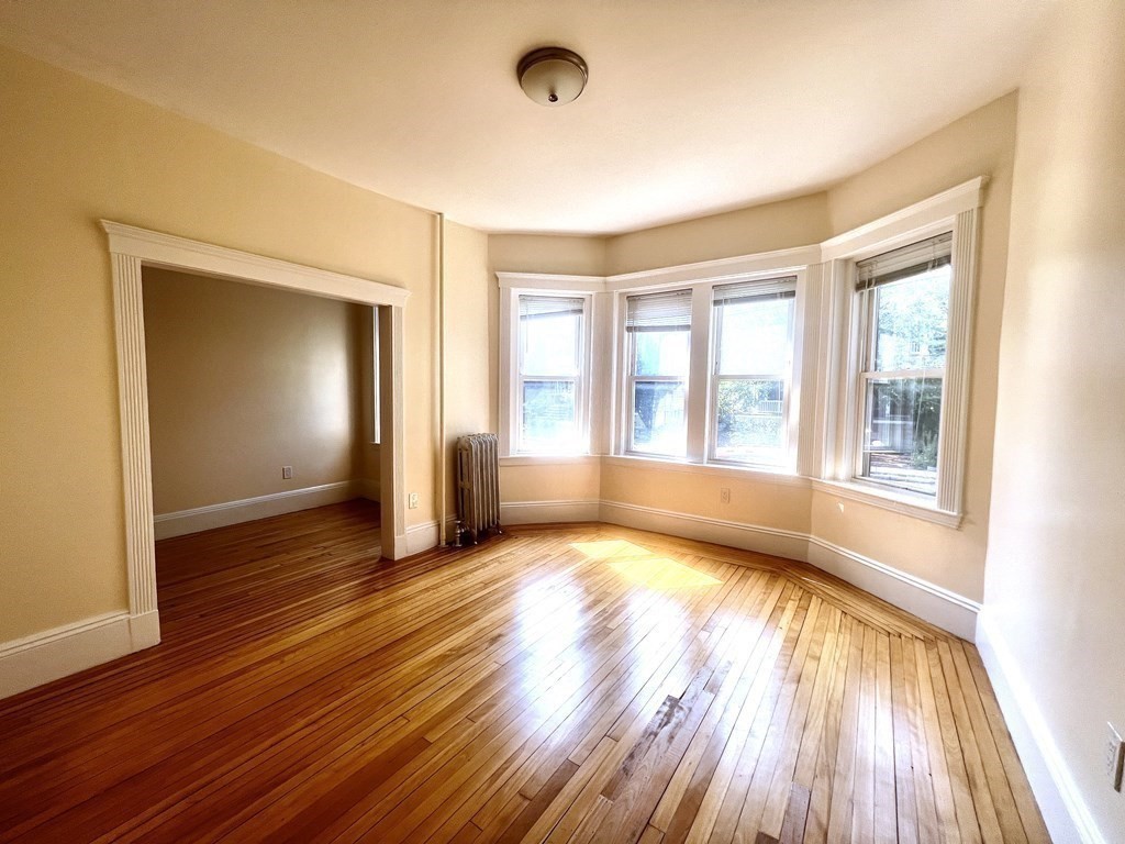 102 Trowbridge Street, Unit 2L Cambridge, MA 02138 - Photo 1 of 16 a view of an empty room with wooden floor and a window
