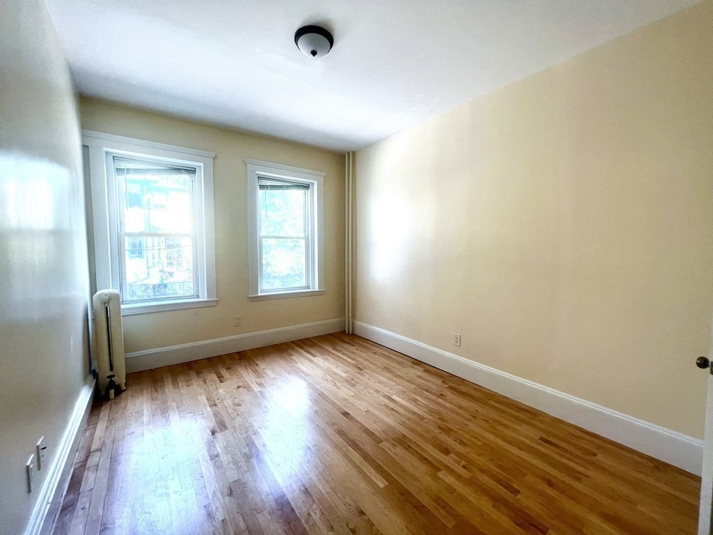 102 Trowbridge Street, Unit 2L Cambridge, MA 02138 - Photo 12 of 16 an empty room with wooden floor and windows