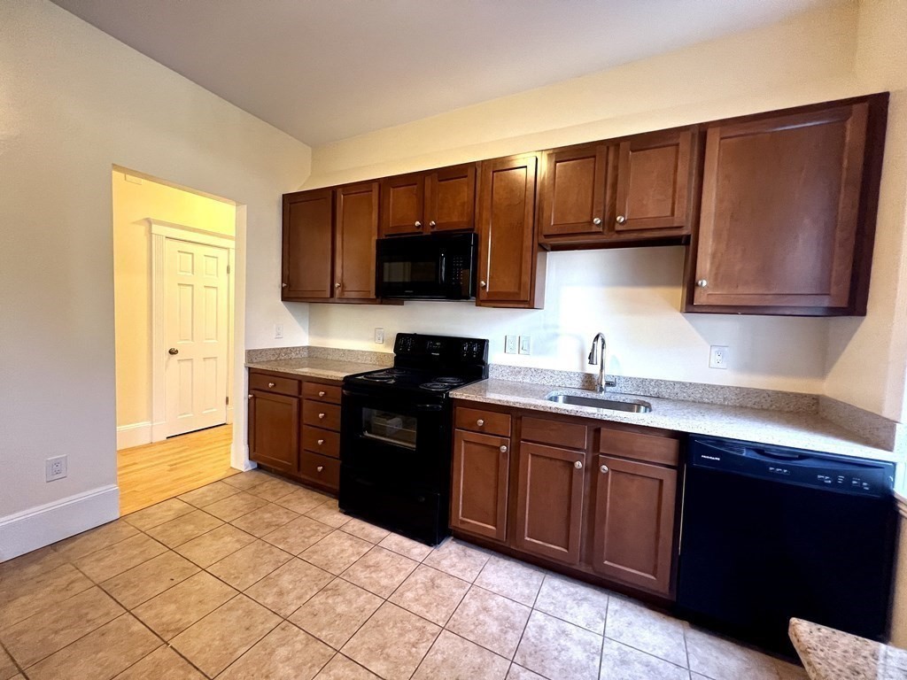 102 Trowbridge Street, Unit 2L Cambridge, MA 02138 - Photo 13 of 16 a kitchen with stainless steel appliances granite countertop a sink and a stove top oven