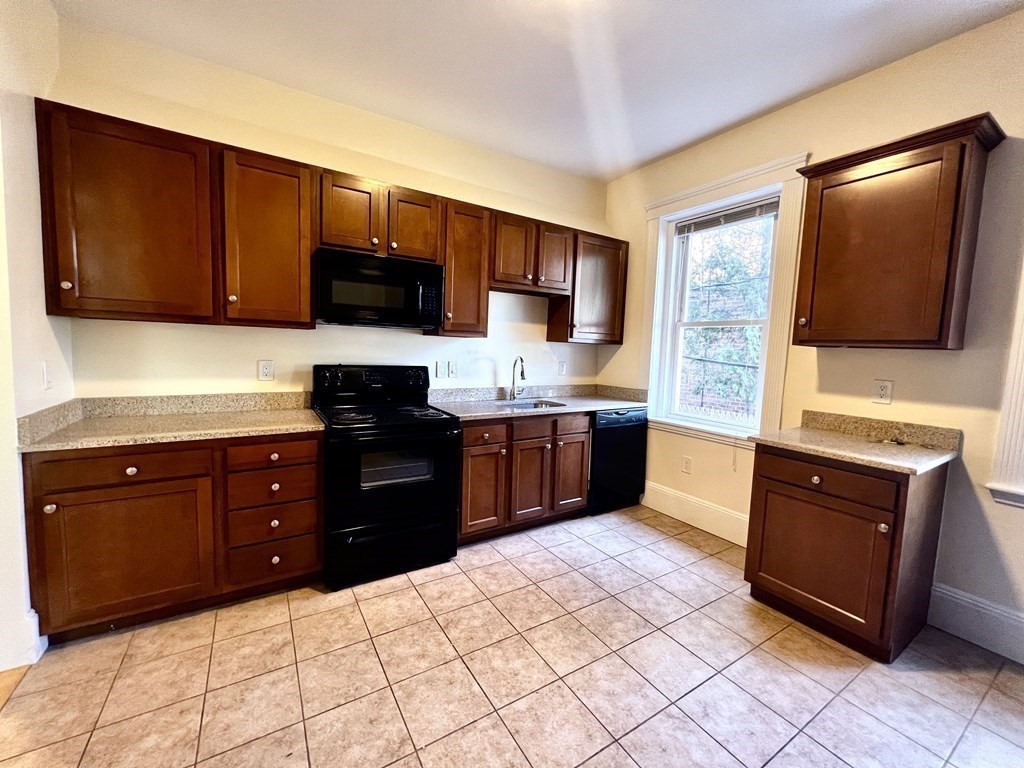 102 Trowbridge Street, Unit 2L Cambridge, MA 02138 - Photo 14 of 16 a kitchen with stainless steel appliances granite countertop a stove a sink and a microwave