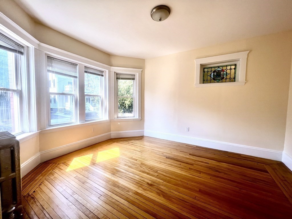 102 Trowbridge Street, Unit 2L Cambridge, MA 02138 - Photo 2 of 16 a view of an empty room with wooden floor and a window