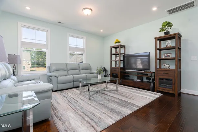 a spacious bedroom with a bed and wooden floor