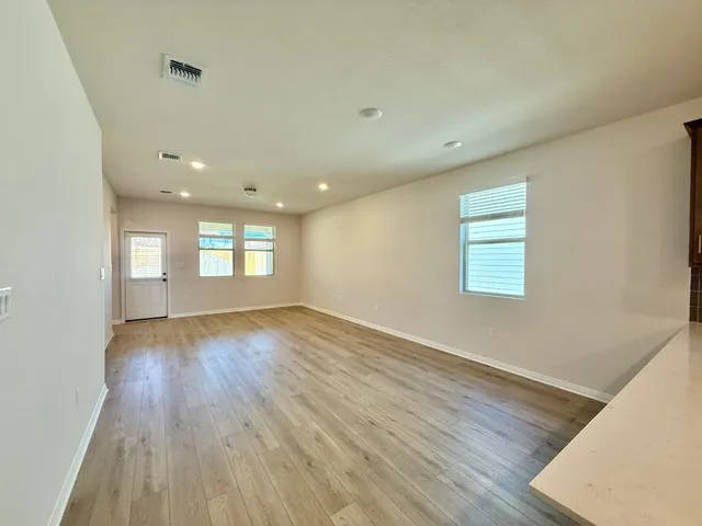 a view of empty room with window and wooden floor