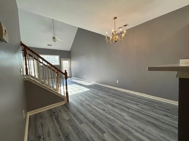 a view of a room with wooden floor and a ceiling fan
