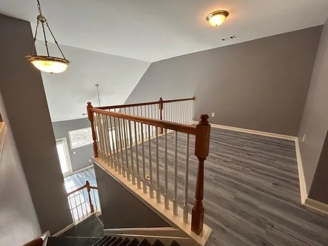 a view of a livingroom with wooden floor and staircase