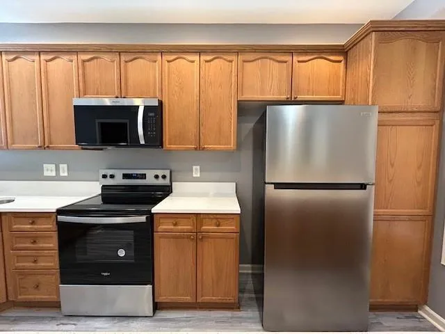 a kitchen with a refrigerator a microwave a stove and cabinets