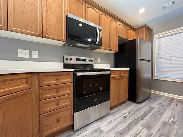 a kitchen with stainless steel appliances a stove microwave and refrigerator