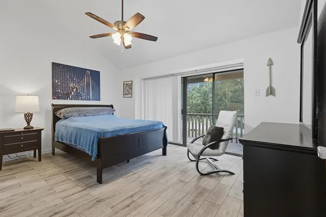 a bedroom with a bed and a table with wooden floor