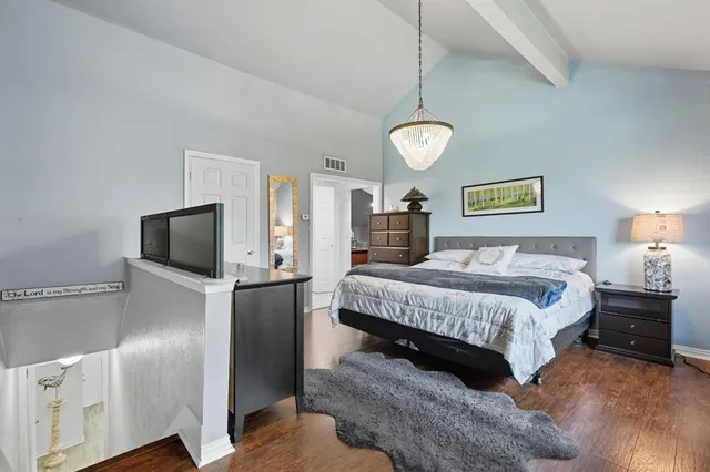 a spacious bedroom with a bed and a flat screen tv