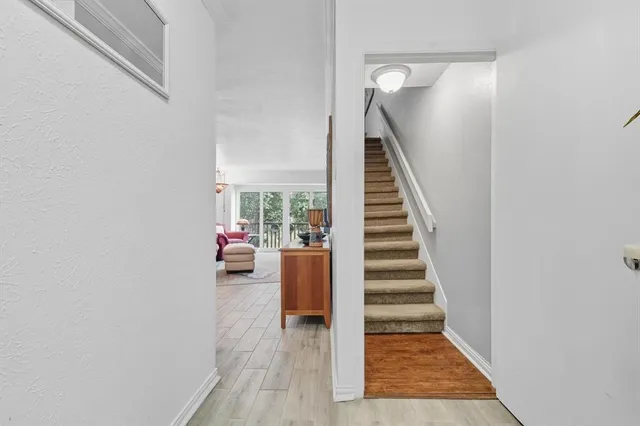 a view of a livingroom with wooden floor and stairs