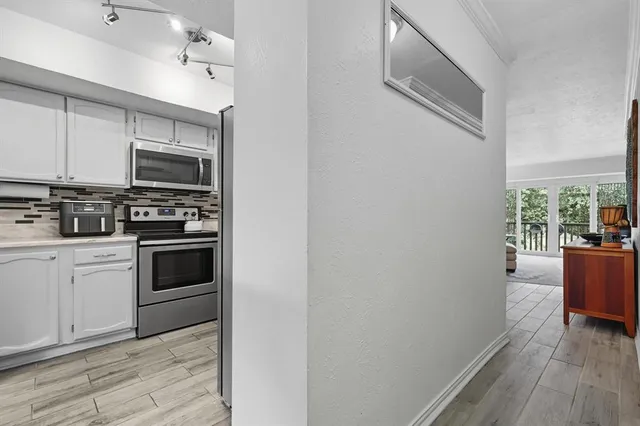 a kitchen with cabinets stainless steel appliances and wooden floor