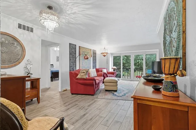 a living room with furniture a fireplace and a chandelier