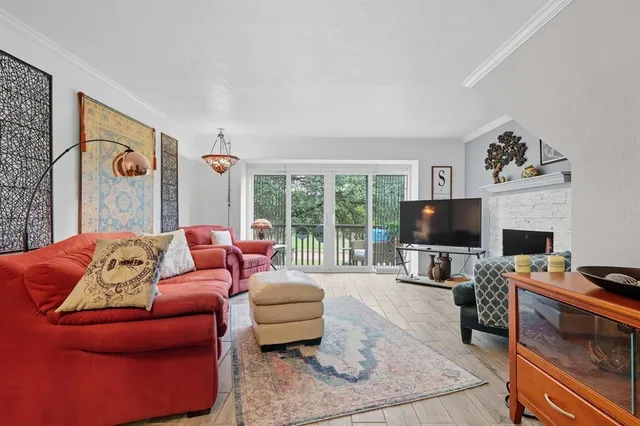 a living room with furniture a flat screen tv and a fireplace