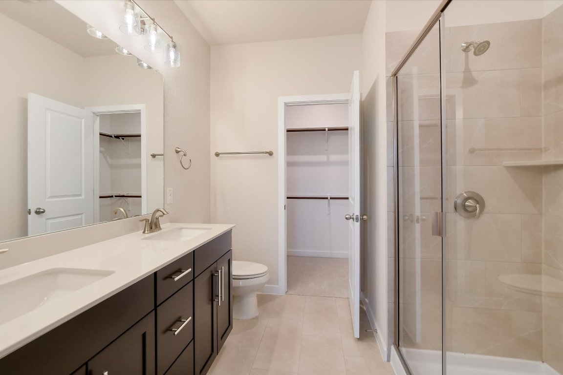 2500 Forest Creek Drive, Unit 2004 Round Rock, TX 78665 - Photo 14 of 27 a bathroom with a double vanity sink a mirror and a shower