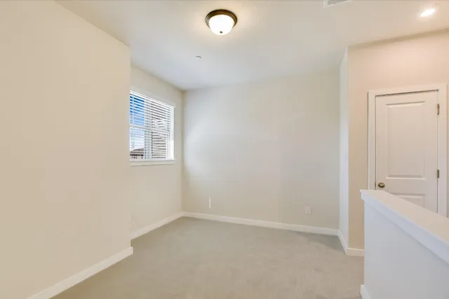 a view of an empty room with a window and a bathroom