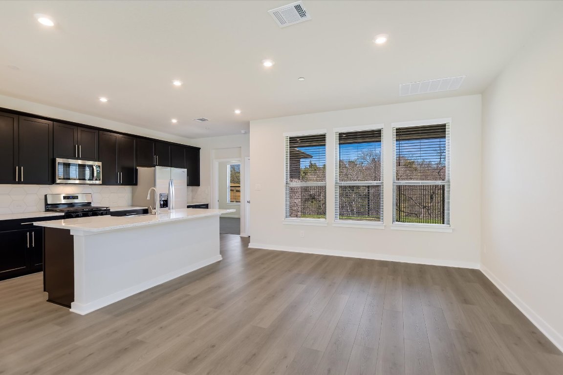 2500 Forest Creek Drive, Unit 2004 Round Rock, TX 78665 - Photo 5 of 27 a large kitchen with stainless steel appliances a large counter top and a wooden floors