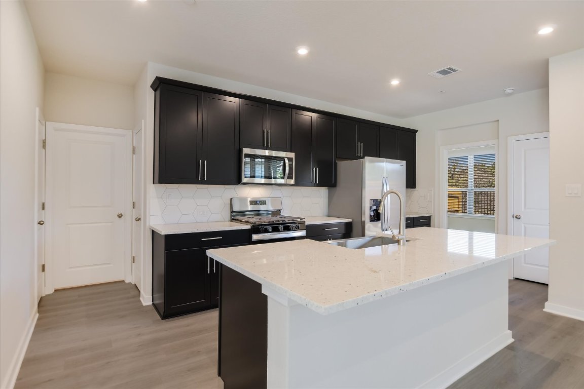 2500 Forest Creek Drive, Unit 2004 Round Rock, TX 78665 - Photo 6 of 27 a kitchen with a sink a stove and refrigerator