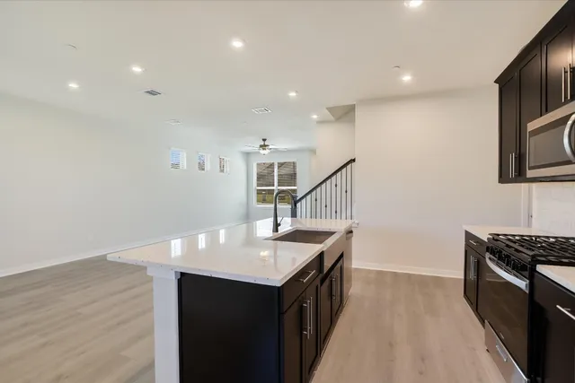 a large kitchen with stainless steel appliances a large counter top stove microwave and refrigerator