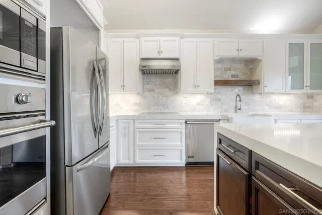 a kitchen with stainless steel appliances a refrigerator sink and cabinets