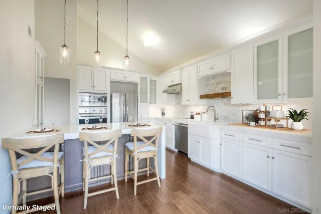 a kitchen with a dining table chairs and white cabinets