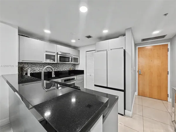 a kitchen with stainless steel appliances granite countertop a sink counter space and cabinets